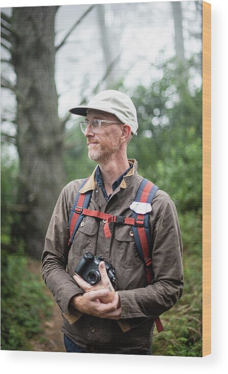 Photographer Wood Print featuring the photograph Portrait Of Photographer With Hat Holding Camera In Forest by Cavan Images