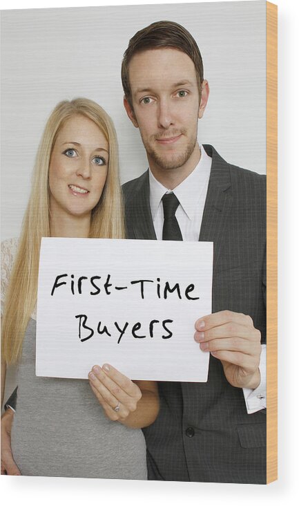 Young Men Wood Print featuring the photograph A smart young couple holding a sign by Tom And Steve