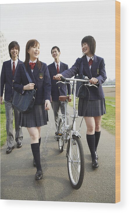 Education Wood Print featuring the photograph Four Students in Uniform Walking Outdoors, One Holding a Bicycle by Digital Vision.