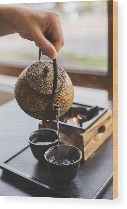 Kyoto Prefecture Wood Print featuring the photograph Green tea is being poured in a cup by a man by Alexander Spatari