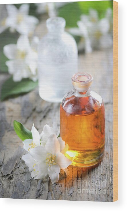 Essential Wood Print featuring the photograph Homemade Essential oil and fresh jasmine flower by Jelena Jovanovic