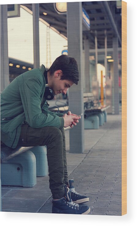 Railroad Station Wood Print featuring the photograph Jugendlicher hört Musik und wartet auf dem Zug by Lucaa15