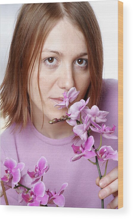 Holding Wood Print featuring the photograph Young woman smelling orchid, portrait, close up by Loop Delay