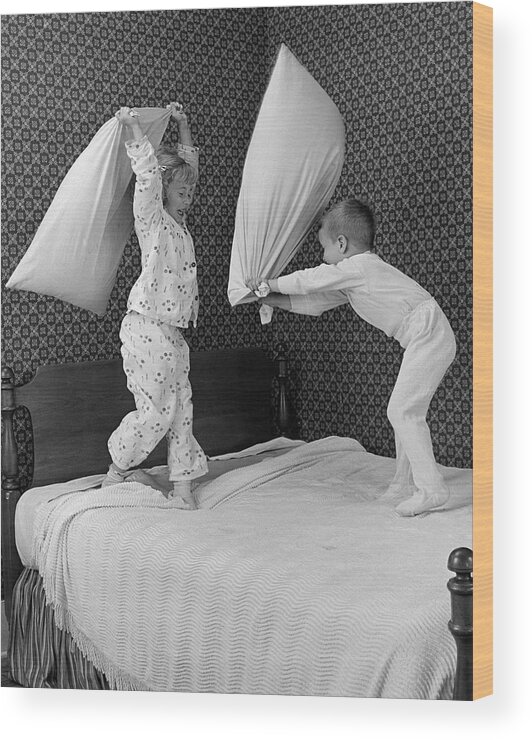 1950s Wood Print featuring the photograph Boy And Girl Having A Pillow Fight by B. Taylor/ClassicStock