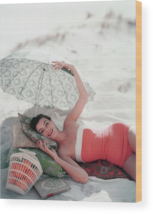 Model Ann Gunning Under Beach Umbrella Wood Print featuring the photograph Vogue July 1st, 1954 by Karen Radkai