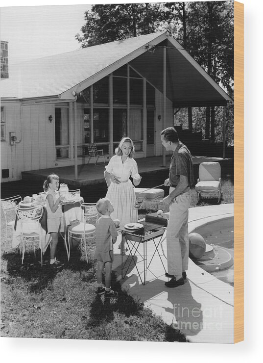 1950s Wood Print featuring the photograph Family Grilling In Backyard, C.1950s by H. Armstrong Roberts/ClassicStock