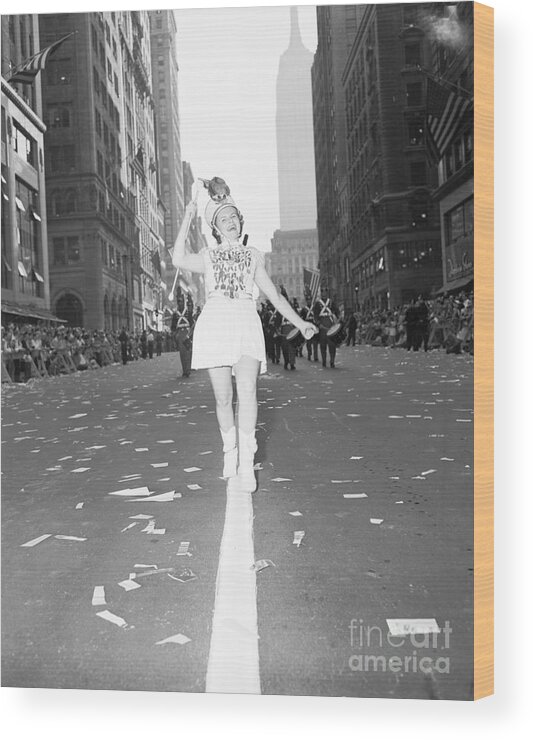 Marching Wood Print featuring the photograph Girl Twirls Baton Leading Marching Band by Bettmann