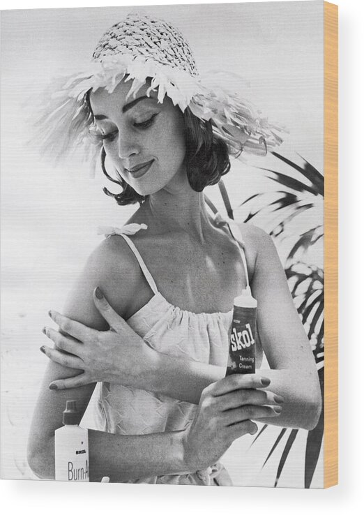  Wood Print featuring the photograph Young Woman Applies Tanning Cream by Underwood Archives