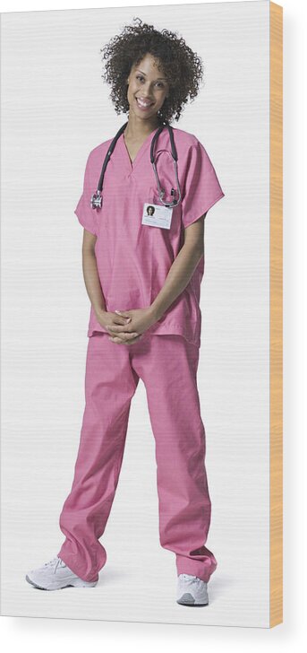 Expertise Wood Print featuring the photograph Full Length Portrait Of A Young Adult Female Nurse In Pink Scrubs As She Smiles by Photodisc