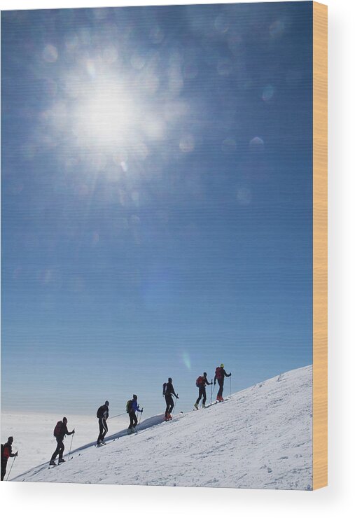 Following Wood Print featuring the photograph Skiers Ascending An Alpine Slope by Buena Vista Images