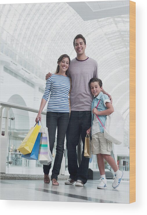 Mid Adult Wood Print featuring the photograph Smiling family shopping together in mall by Chris Ryan