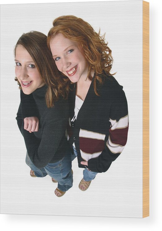 Child Wood Print featuring the photograph Two Caucasian Teenager Girls In Jeans And A Black Sweaters Smiles Up Into The Camera by Photodisc