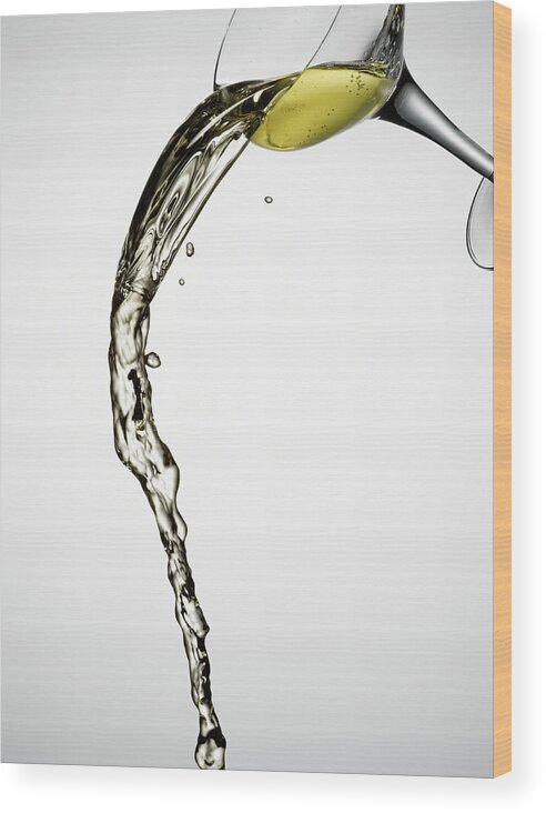 White Background Wood Print featuring the photograph White Wine Spilling From Glass by Andy Roberts