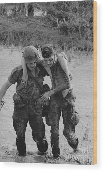 Vietnam War Wood Print featuring the photograph Soldier Helping Wounded Soldier by Bettmann