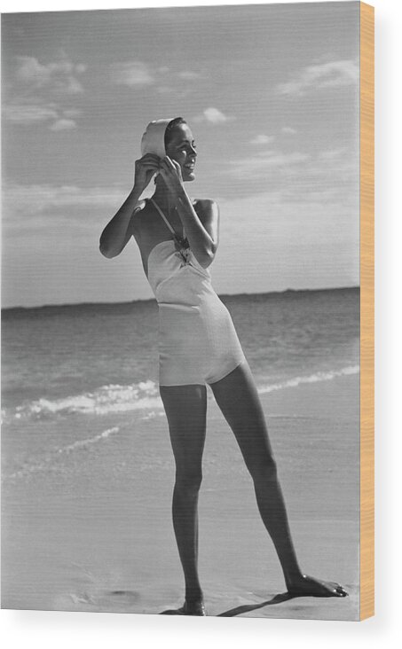 Accessories Wood Print featuring the photograph Model on a Beach Fastening Her Bathing Cap by Toni Frissell