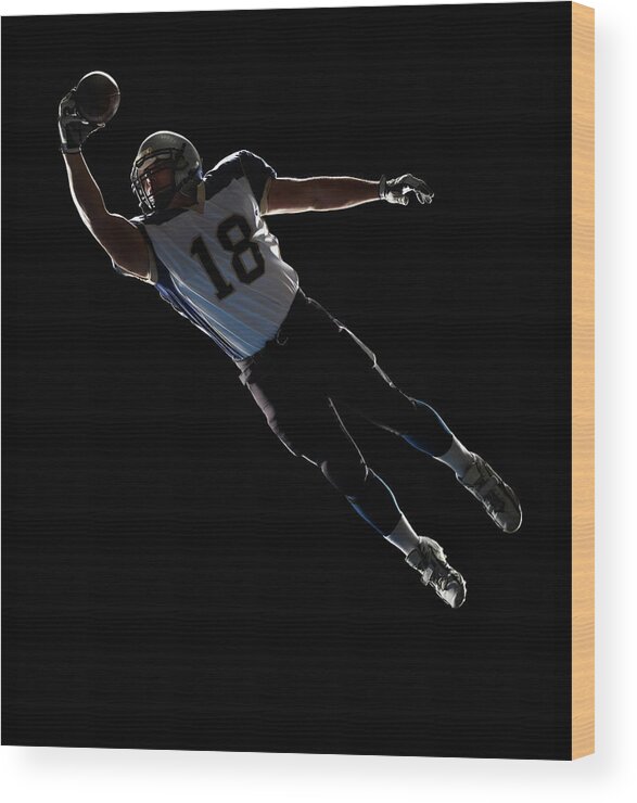 Sports Helmet Wood Print featuring the photograph American Football Player Leaping To by Lewis Mulatero