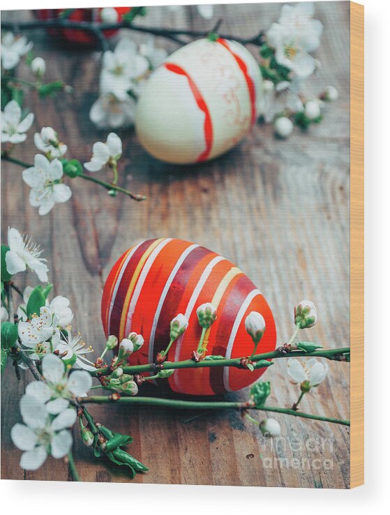 Easter Wood Print featuring the photograph Closeup of colorful painted easter eggs and cherry blossom branc by Jelena Jovanovic