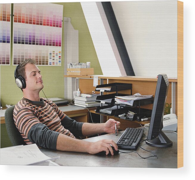 Man Wearing Headphones Sitting At Computer Eyes Closed Smiling