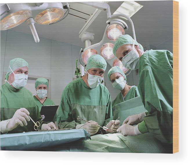 Expertise Wood Print featuring the photograph Group of surgeons in operating theatre, portrait by Jochen Sands