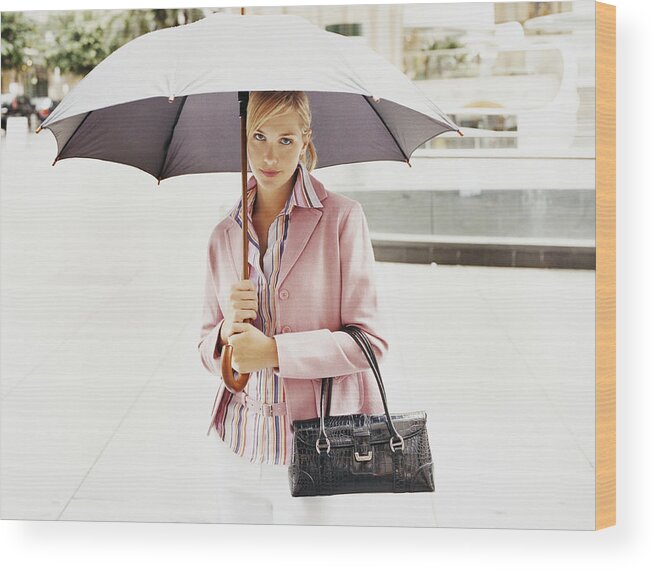 Part Of A Series Wood Print featuring the photograph Portrait of a Young Woman Holding an Umbrella in the City by Digital Vision.