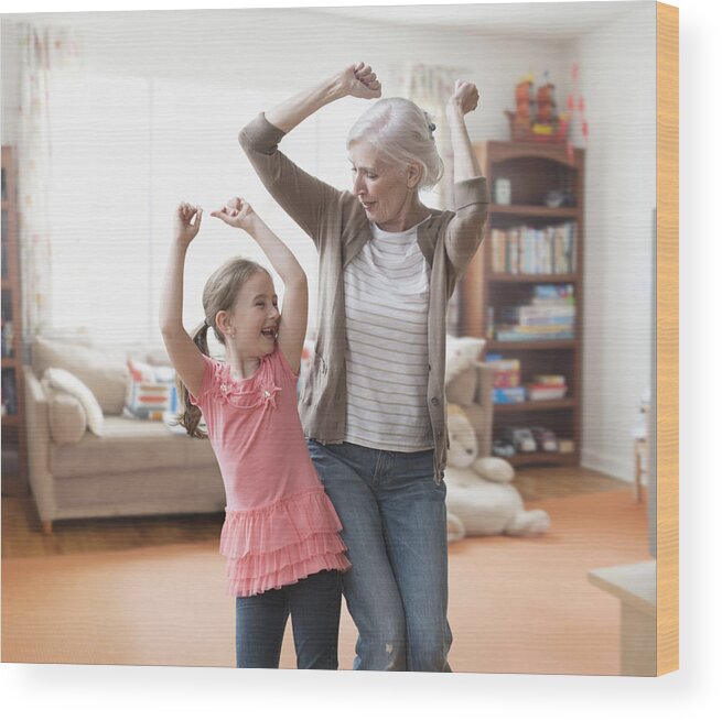 Human Arm Wood Print featuring the photograph Caucasian grandmother and granddaughter dancing in living room by Jose Luis Pelaez Inc