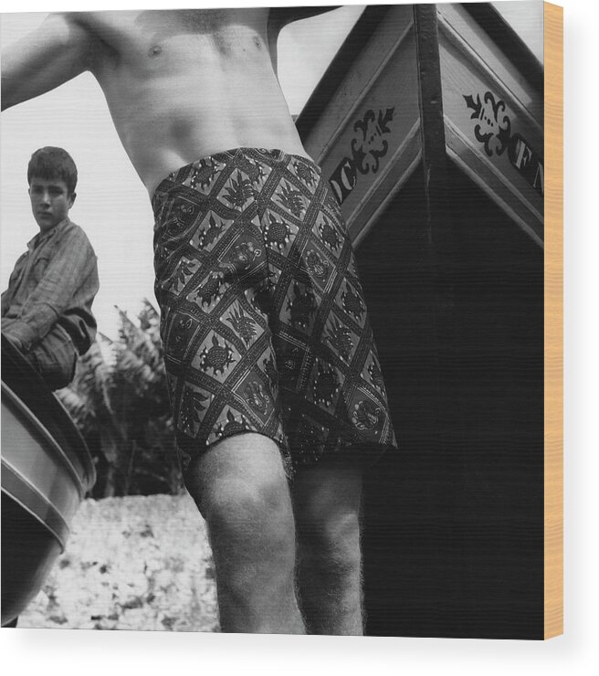 Swimwear Wood Print featuring the photograph A Man Wearing Patterned Shorts And A Teenage Boy by Leonard Nones