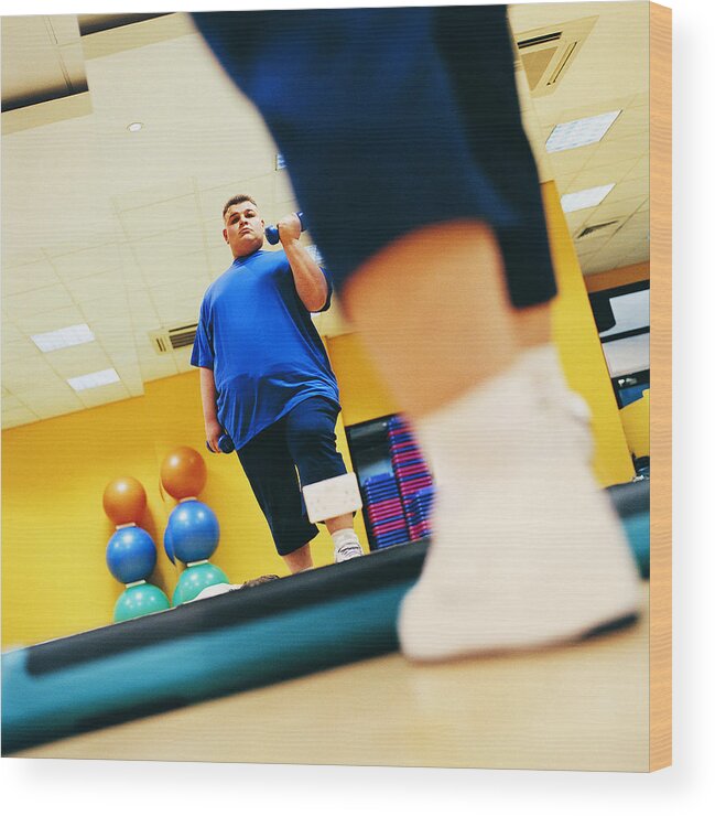 Three Quarter Length Wood Print featuring the photograph Overweight Man Weight Training in a Gym by Digital Vision.