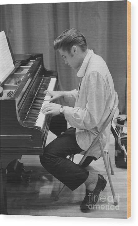Elvis Presley Wood Print featuring the photograph Elvis Presley on piano while waiting for a show to start 1956 by The Harrington Collection