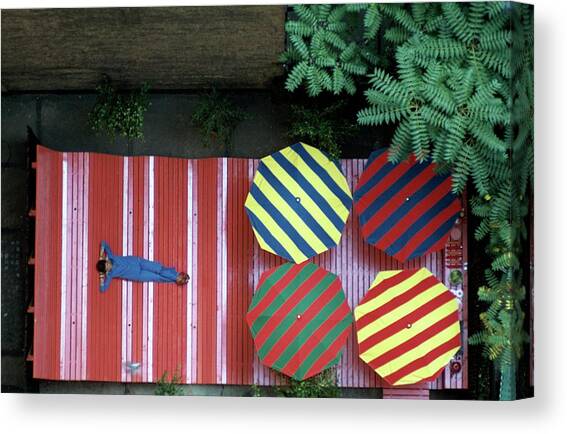 A Patio With Striped Umbrellas Canvas Art Print by James Mathews