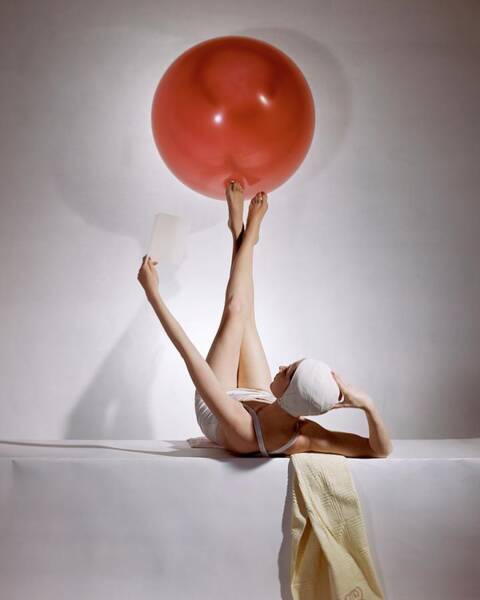 A Model Balancing A Red Ball On Her Feet Art Print