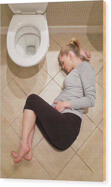 Pregnant Woman Lying On Bathroom Floor Photograph by Ian ...