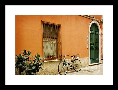Bicycle Parked Against An Orange House With A Green Door In Tuscany' Framed Prints