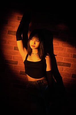  Photograph - Young Chinese woman against a brick wall portrait in a spotlight by Philippe Lejeanvre