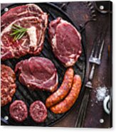 Various Cuts Of Raw Meat Shot From Above On A Cast Iron Grill Acrylic Print