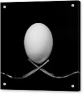 White Egg  Resting On Two Metal And Shiny Forks On A Black Backg Acrylic Print