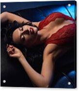 ?lluring Woman In Red Bodysuit With Her Eyes Closed Laying On Black Leather Sofa Acrylic Print