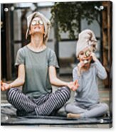 Relaxed mother and daughter exercising Yoga in the morning at home. Acrylic Print
