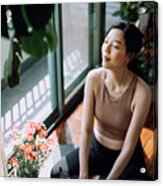 Active Young Asian Sports Woman Taking A Break After Working Out At Home, Sitting On Exercise Mat Taking A Deep Breath With Her Eyes Closed. Sports And Exercise Routine. Health, Fitness And Wellness Concept Acrylic Print