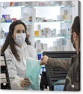 Female Pharmacist Wearing A Surgical Mask Gives Medication To The Patient Acrylic Print
