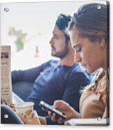 Hispanic Couple With Newspaper And Cell Phone In Coffee Shop Acrylic Print