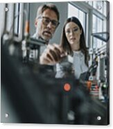 Male Scientist With Young Woman Examining Machinery In Laboratory Acrylic Print