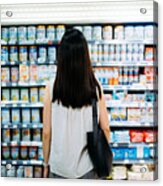Rear View Of Young Asian Mother Groceries Shopping For Baby Products In A Supermarket. She Is Standing In Front Of The Baby Product Aisle And Have No Idea Which Product To Choose From Acrylic Print