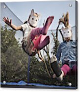 Two Children Wearing Rabbit Masks And Bouncing On A Trampoline Acrylic Print