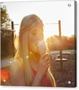 Young Woman Eating Ice Cream Cone In Park At Sunset Acrylic Print