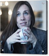 Young Woman Looking Up Whilst Drinking Coffee In Cafe Acrylic Print