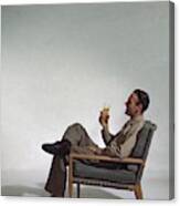 A Man Sitting In An Armchair With A Drink Canvas Print