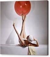 A Model Balancing A Red Ball On Her Feet Canvas Print