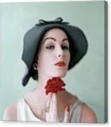 A Model Wearing A Hat And Holding A Flower Canvas Print