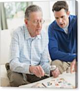 Caucasian Father And Son Examining Stamp Collection Canvas Print
