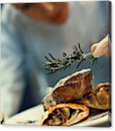 Chef Placing Finishing Touches On A Meal. Canvas Print